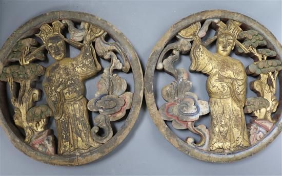 A pair of Chinese carved figurative roundels with gilt and hand painted decoration diameter 34cm